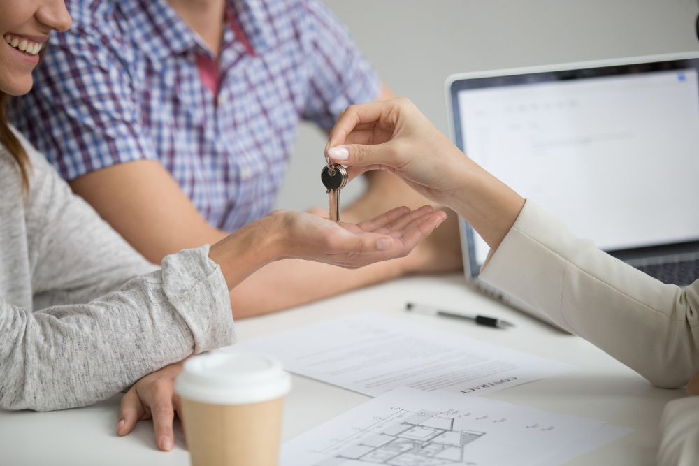 buying-new-house-concept-realtor-giving-keys-couple-closeup-1